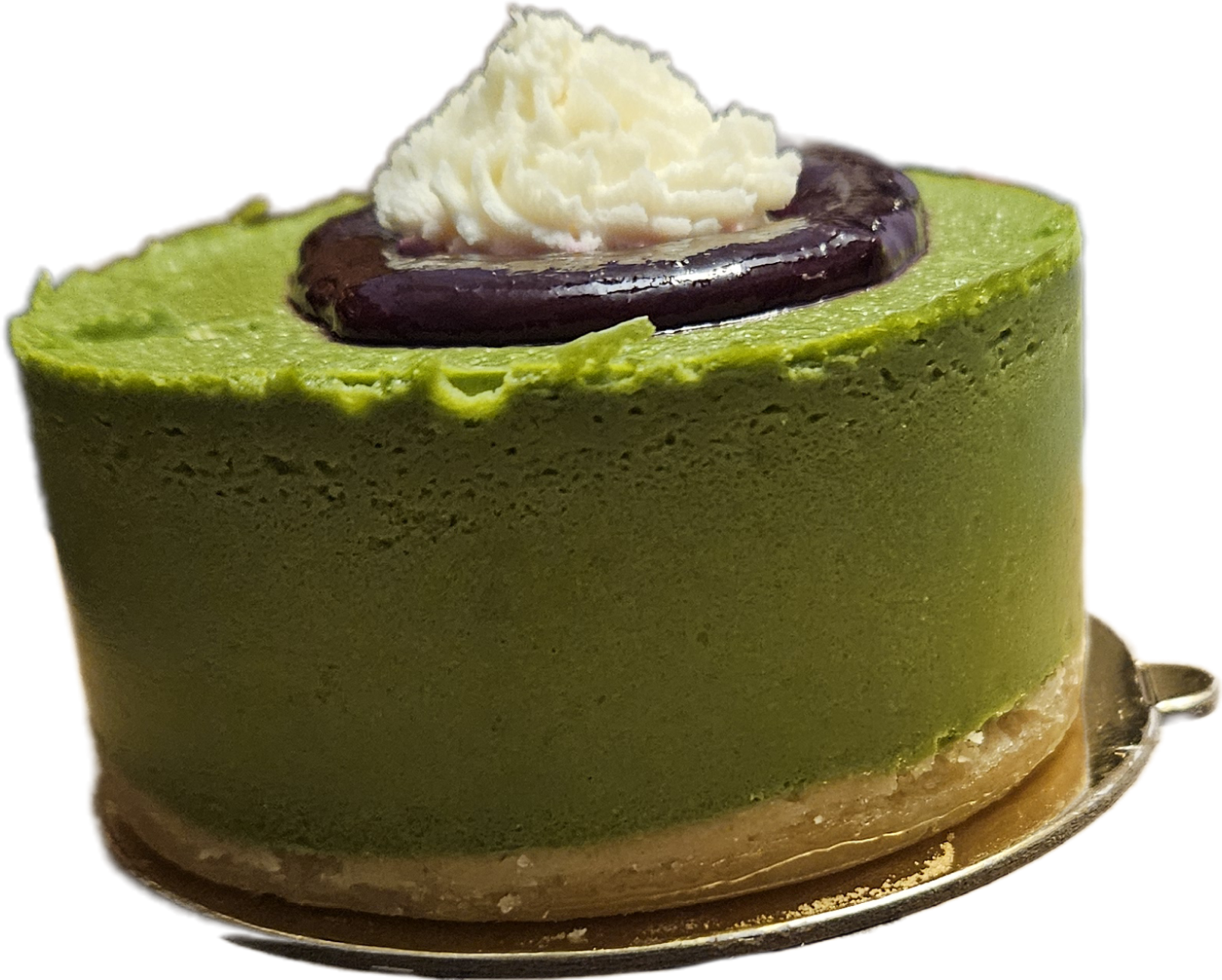 small round japanese style cheesecake, matcha flavor, white whipped icing dollop on top of a bed of a berry sauce or compote